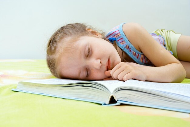 Menina adormecida lendo seu livro favorito