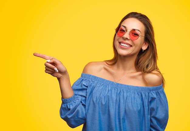 Menina alegre apontando para fora com um sorriso