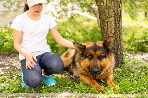 Menina alegre com um cão pastor alemão.