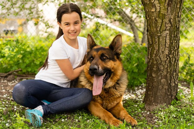 Menina alegre com um cão pastor alemão.