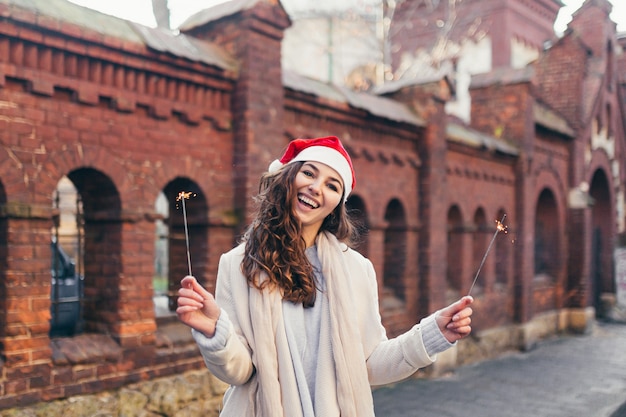 Foto menina alegre com um chapéu de natal sorrindo para a câmera