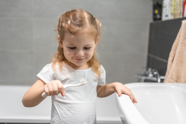 Foto menina alegre escovando os dentes no banho pessoa foto de alta qualidade