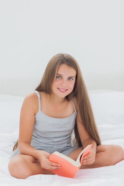 Foto menina alegre lendo um livro