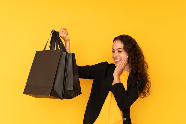 Menina alegre olha para o conceito de venda de sacolas de compras