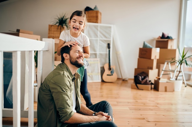 Foto menina alegre se divertindo com o pai enquanto se muda para uma nova casa