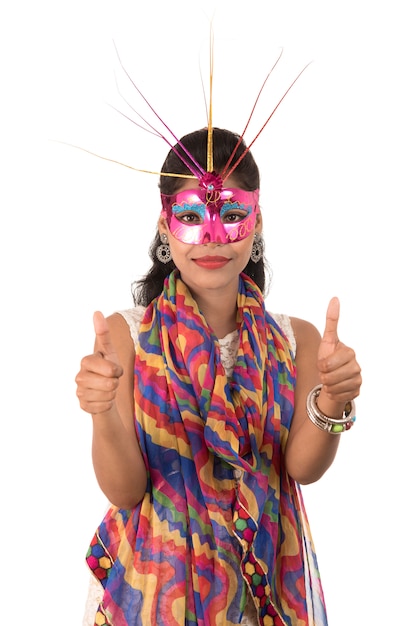 Foto menina alegre sorridente usando máscara de carnaval e mostrando sinal isolado no espaço em branco