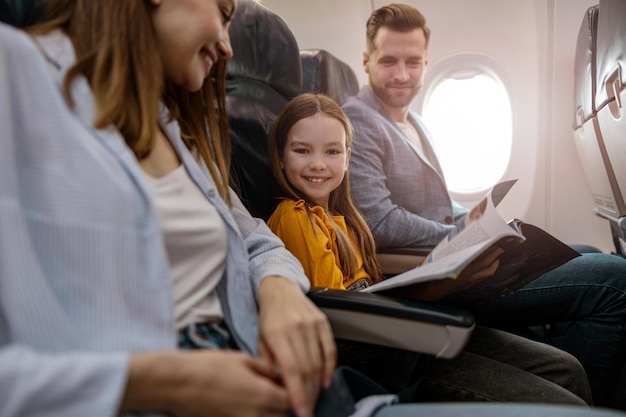 Menina alegre viajando com os pais no avião