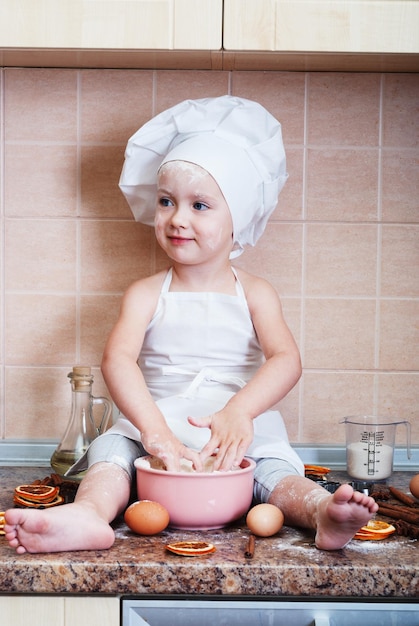 menina amassar massa na cozinha