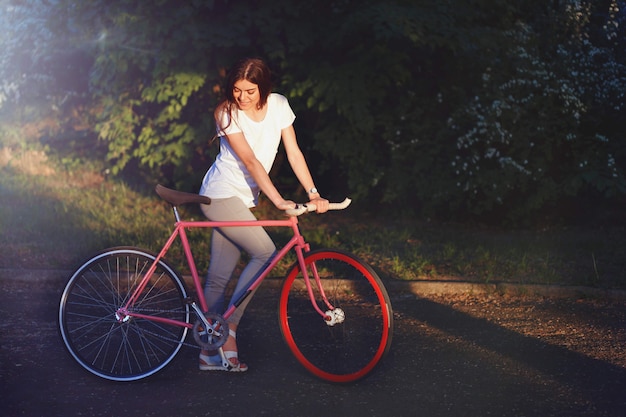 Menina andando com bicicleta por do sol