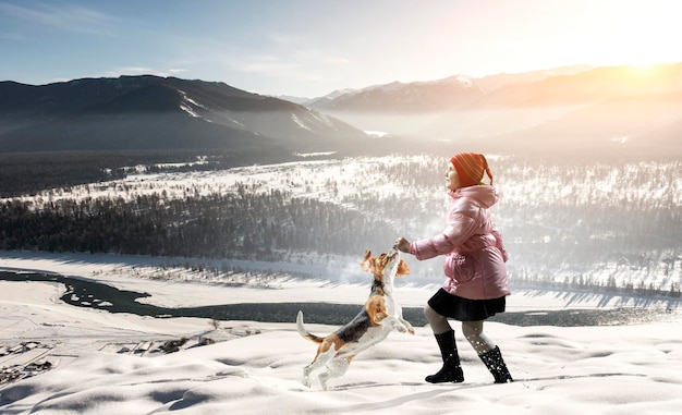 Menina andando com cachorro no inverno. Mídia mista