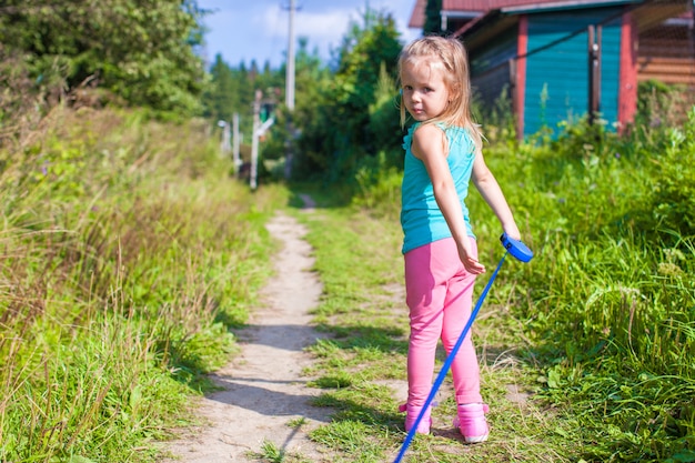 Menina andando com seu cachorro na coleira