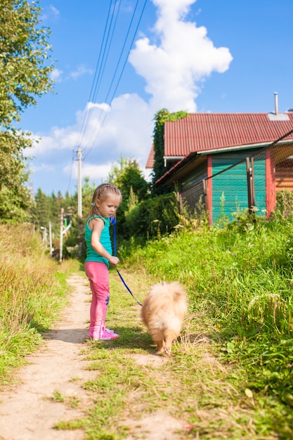 Menina andando com seu cachorro na coleira