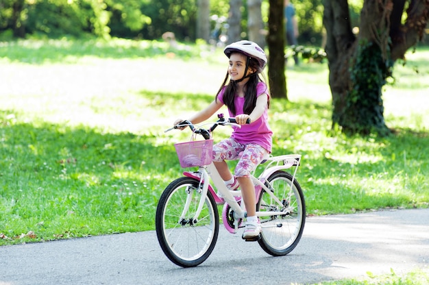 Menina andando de bicicleta em um parque