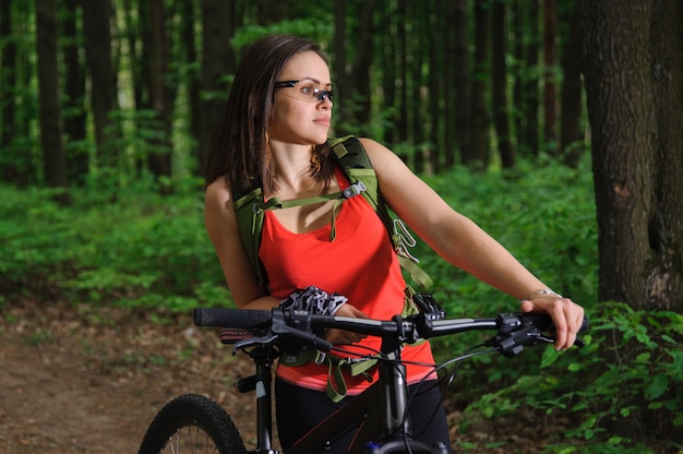 Menina andando de bicicleta na floresta