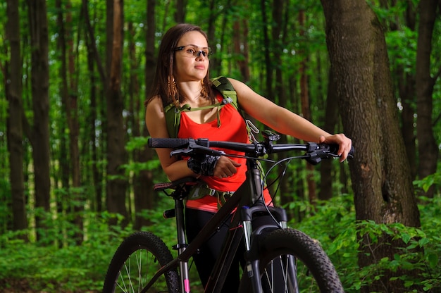 Menina andando de bicicleta na floresta