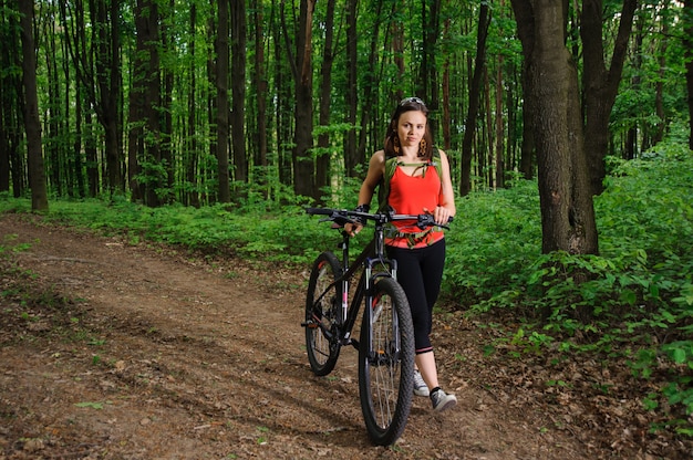 Menina andando de bicicleta na floresta