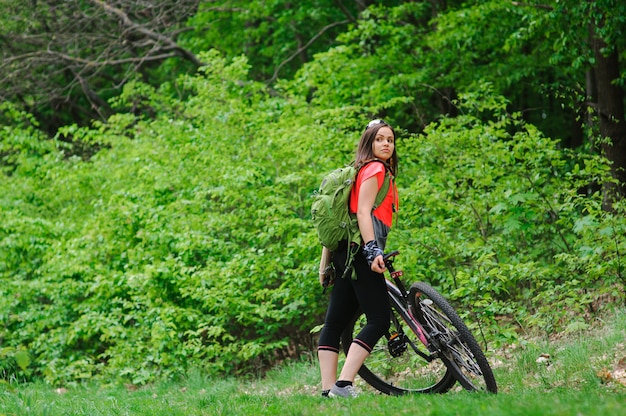 Menina andando de bicicleta na floresta