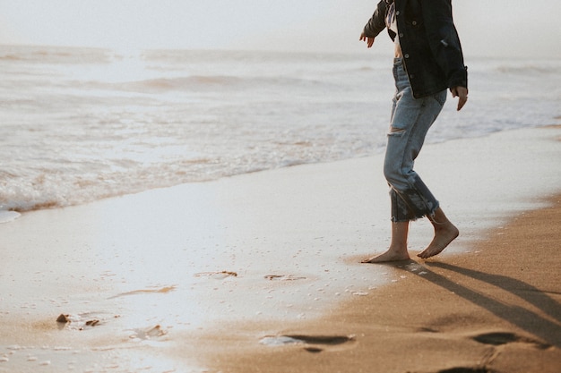 Menina andando descalça na praia