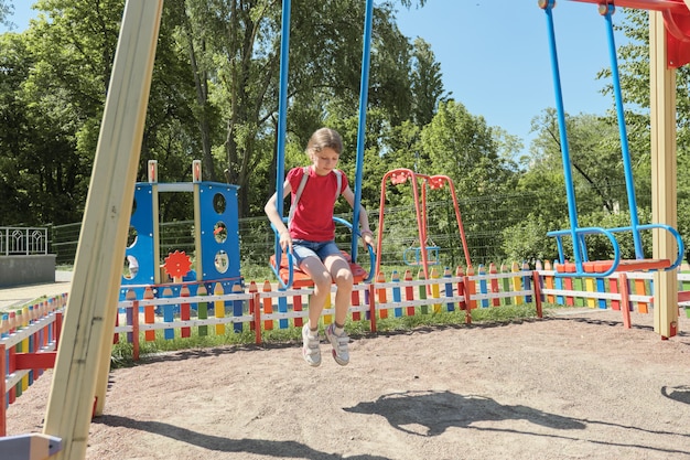 Menina andando no balanço, dia ensolarado de verão