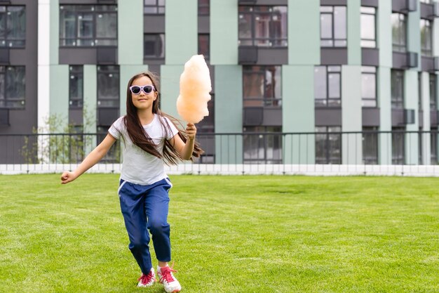 Menina andando no gramado verde no parque.