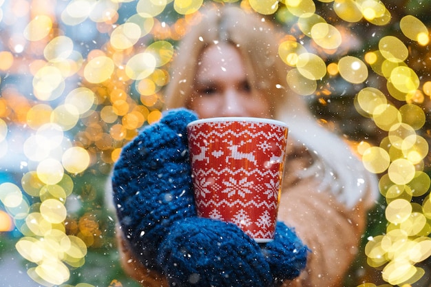 Menina andando no mercado tradicional de Natal, decorado com luzes do feriado na noite de inverno