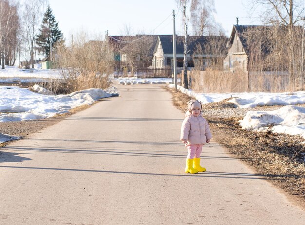 Menina andando pela estrada na aldeia