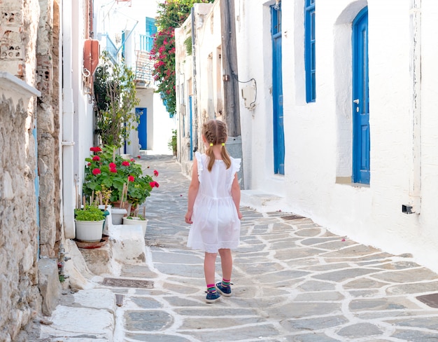 Menina andando pelo beco estreito na Grécia