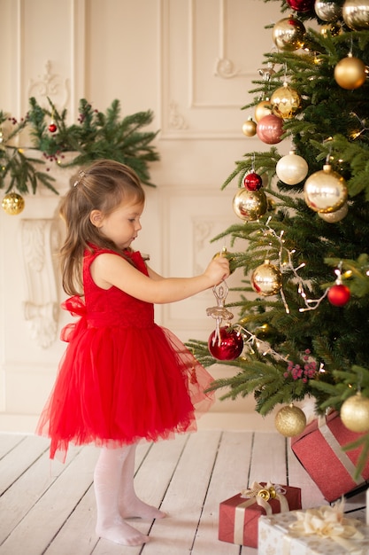 Menina animada para as férias de Natal com todos esses presentes e decoração de conto de fadas.