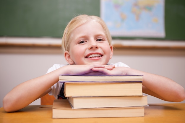 Menina apoiada em livros