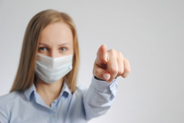 Foto menina apontando o dedo para você com uma máscara médica