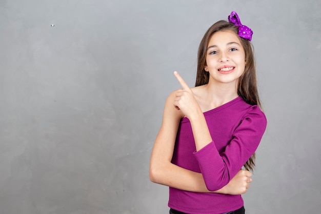 Menina apontando para o lado no espaço livre para texto