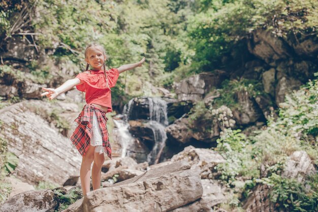 Menina, apreciando a vista da cachoeira em Krasnay Poliana