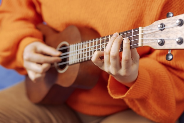 Menina aprende a tocar ukulele em casa