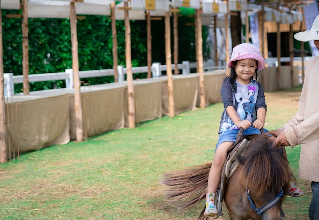 Menina aprendendo a andar a cavalo