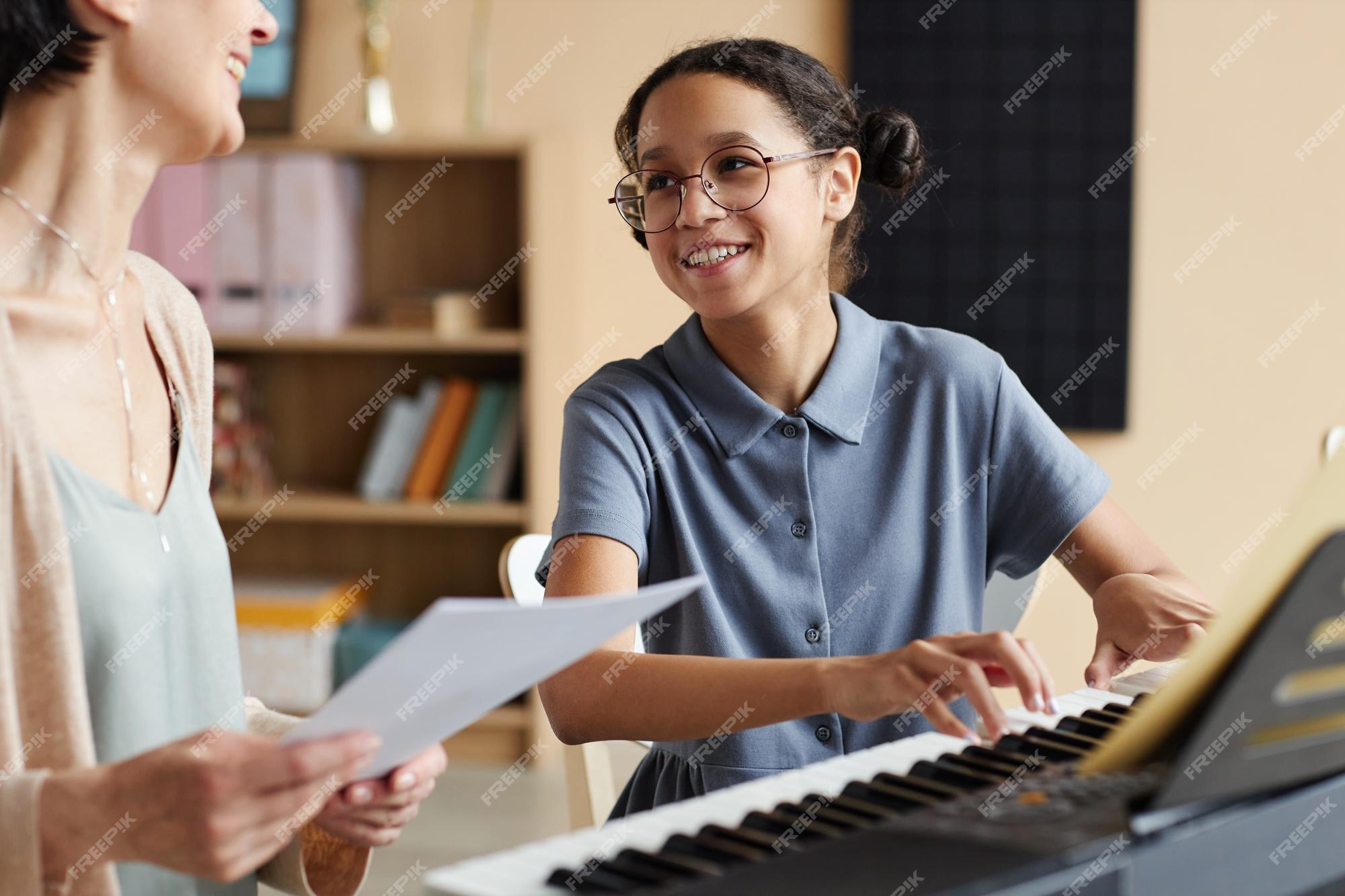 Menina aprende a tocar piano com música online para ensino à