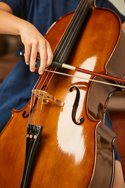 Menina aprendendo a tocar violoncelo em casa