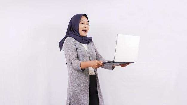 Menina asiática abrindo laptop se sentindo animada, isolada no fundo branco