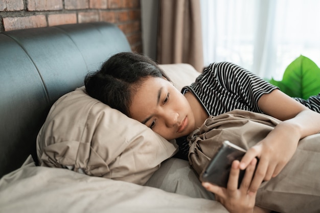 Menina asiática adolescente sentir deprimir enquanto estiver usando o telefone