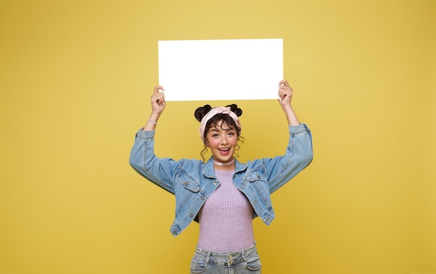 Menina asiática animada segurando bolhas de fala em branco sobre fundo amarelo