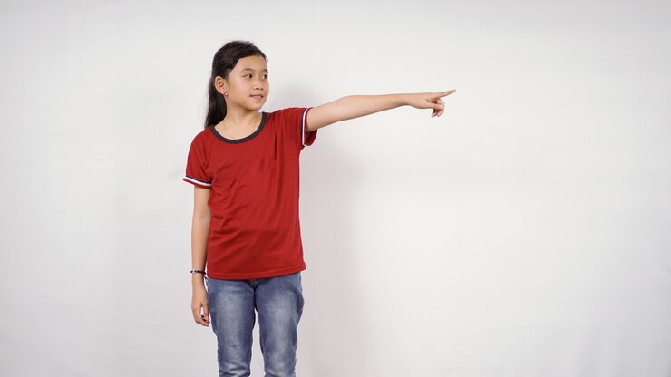 Foto menina asiática apontando isolado no fundo branco
