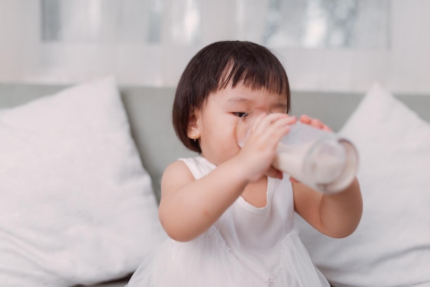 Menina asiática bebendo leite