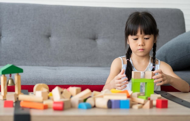 Menina asiática bonita brincando com blocos de brinquedos coloridos crianças brincam com brinquedos educativos no jardim de infância