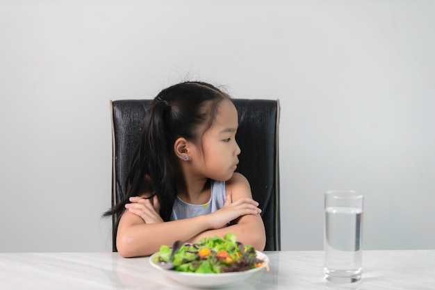 Menina asiática bonita se recusa a comer vegetais saudáveis Nutrição hábitos alimentares saudáveis para crianças conceitoCrianças não gostam de comer vegetais