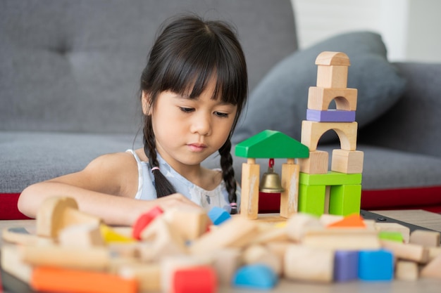 Menina asiática bonitinha brincando com blocos de brinquedos coloridos Crianças brincam com brinquedos educativos no jardim de infância ou creche O jogo criativo do conceito de desenvolvimento infantil Criança no berçário