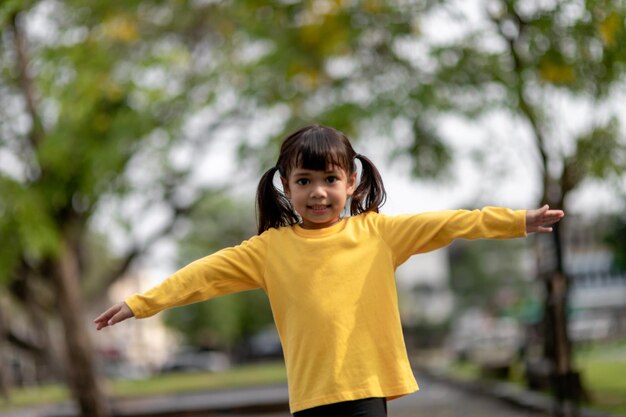 Menina asiática brincando no playground no parque ao ar livremomento feliz e boa emoção