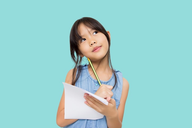Menina asiática com papel e lápis nas mãos olhando para o escritor esperando por musa isolada em fundo verde