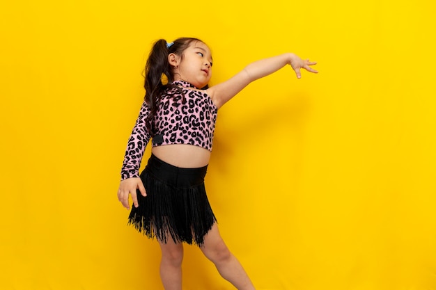 Menina asiática com roupa de dança dança chachacha em fundo amarelo isolado dançarina coreana