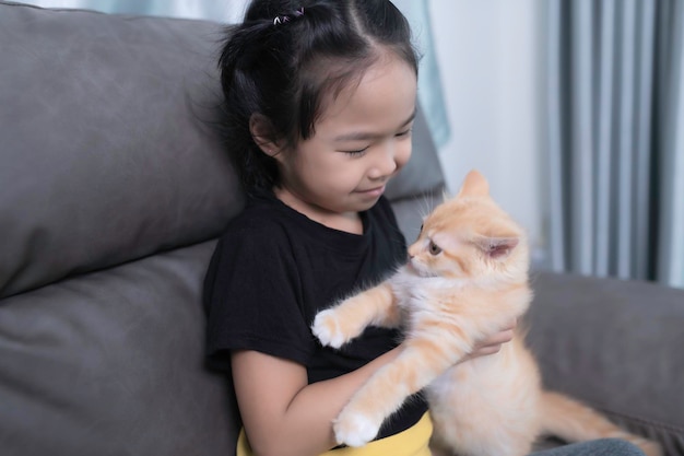 Menina asiática com seu gato fofo, ela brinca com gatinho