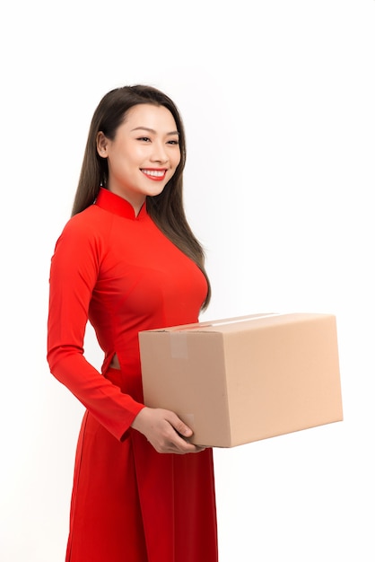 Menina asiática com vestido tradicional vietnamita segurando uma caixa de presente. Saudações de Ano Novo Lunar