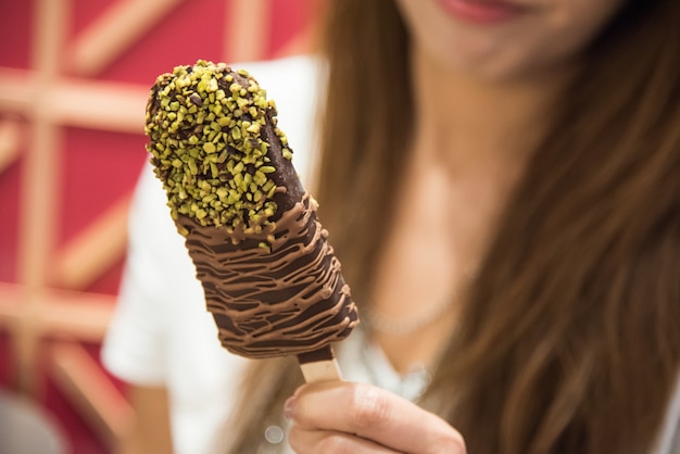 Foto menina asiática comer sorvete delicioso choccolate com sabor pistache greentea, estilo foto vin